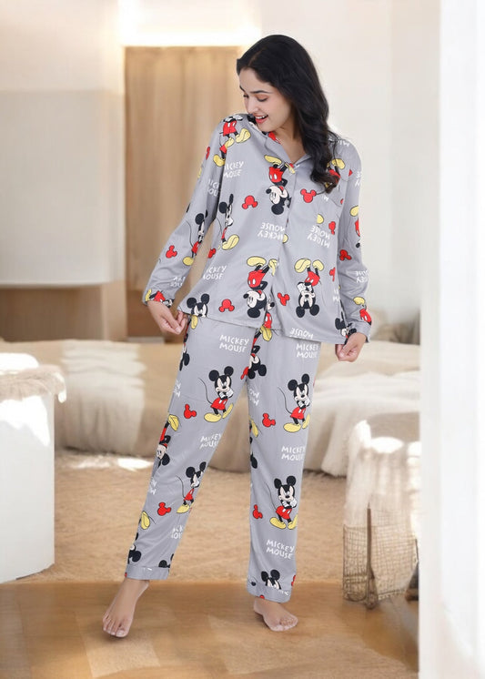 Woman in grey jersey cotton pyjama set with all-over Mickey Mouse print, cozy cartoon loungewear by WakeUp Chicq.