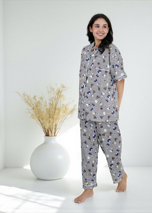Woman wearing Snoopy cartoon black-and-white striped crepe pyjama set with relaxed fit, stylish nightwear by WakeUp Chicq.