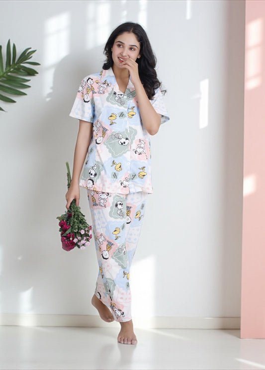 Woman wearing pastel patchwork Snoopy Peanuts cartoon print crushed crepe pyjama set, soft cotton loungewear by WakeUp Chicq.