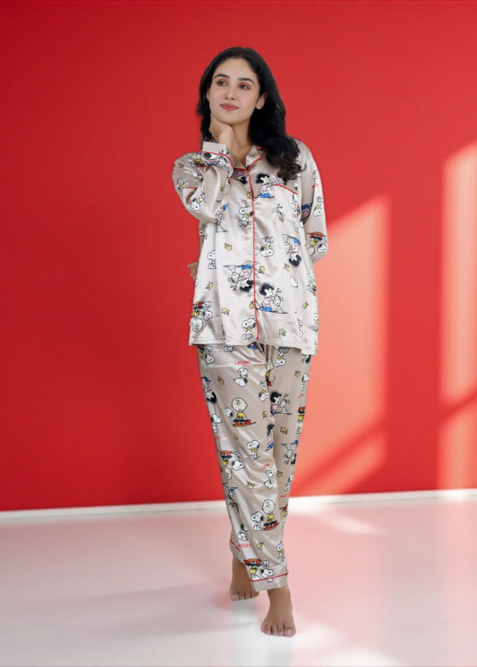 Woman wearing a beige satin Snoopy pyjama set with full sleeves and Peanuts print