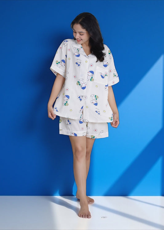 Woman wearing white crushed crepe shorts set with blue and green Snoopy cartoon print, lightweight cotton loungewear by WakeUp Chicq.