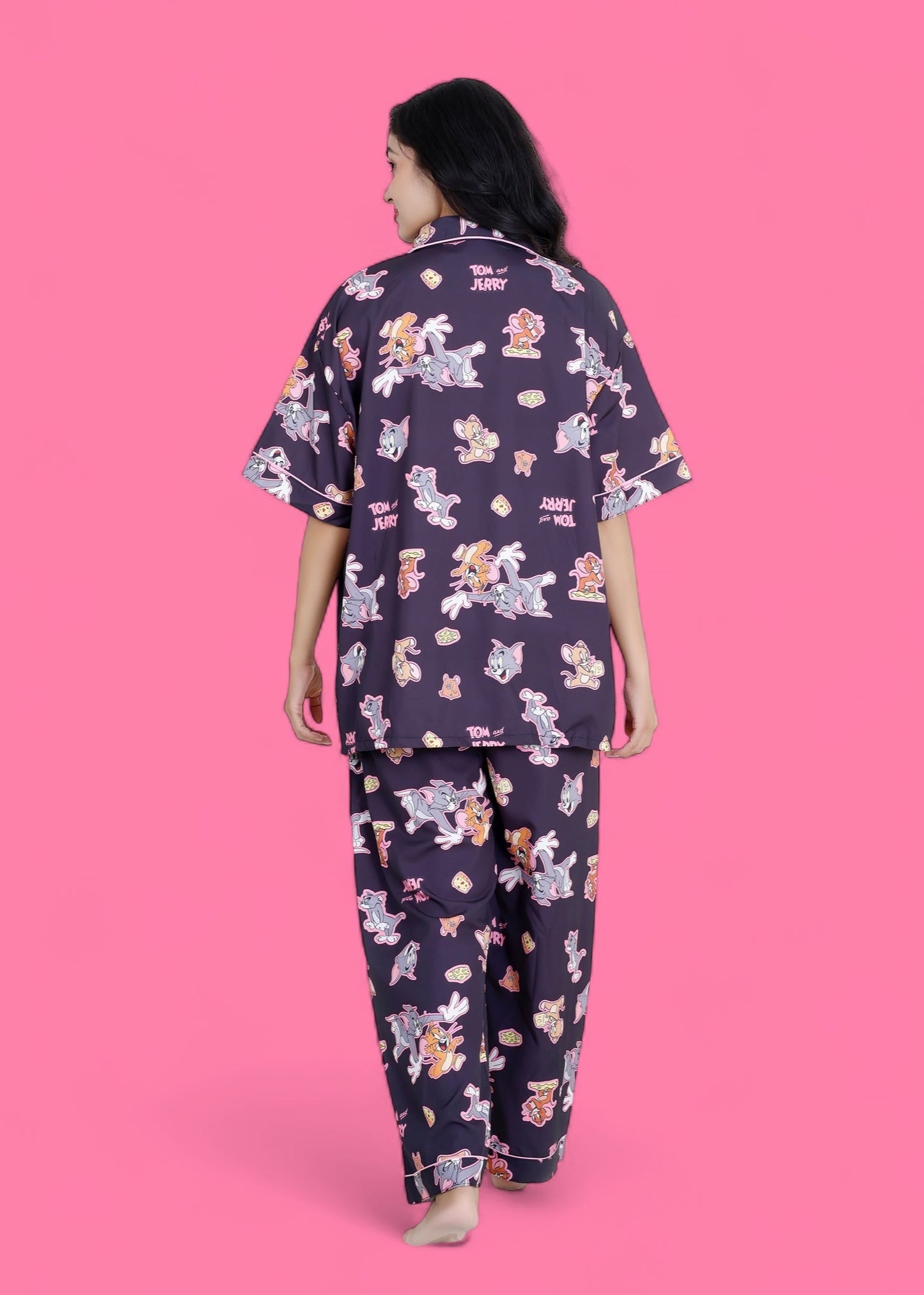 Woman wearing oversized black crepe pyjama set with Tom & Jerry cartoon print, full-sleeve nightwear by WakeUp Chicq.