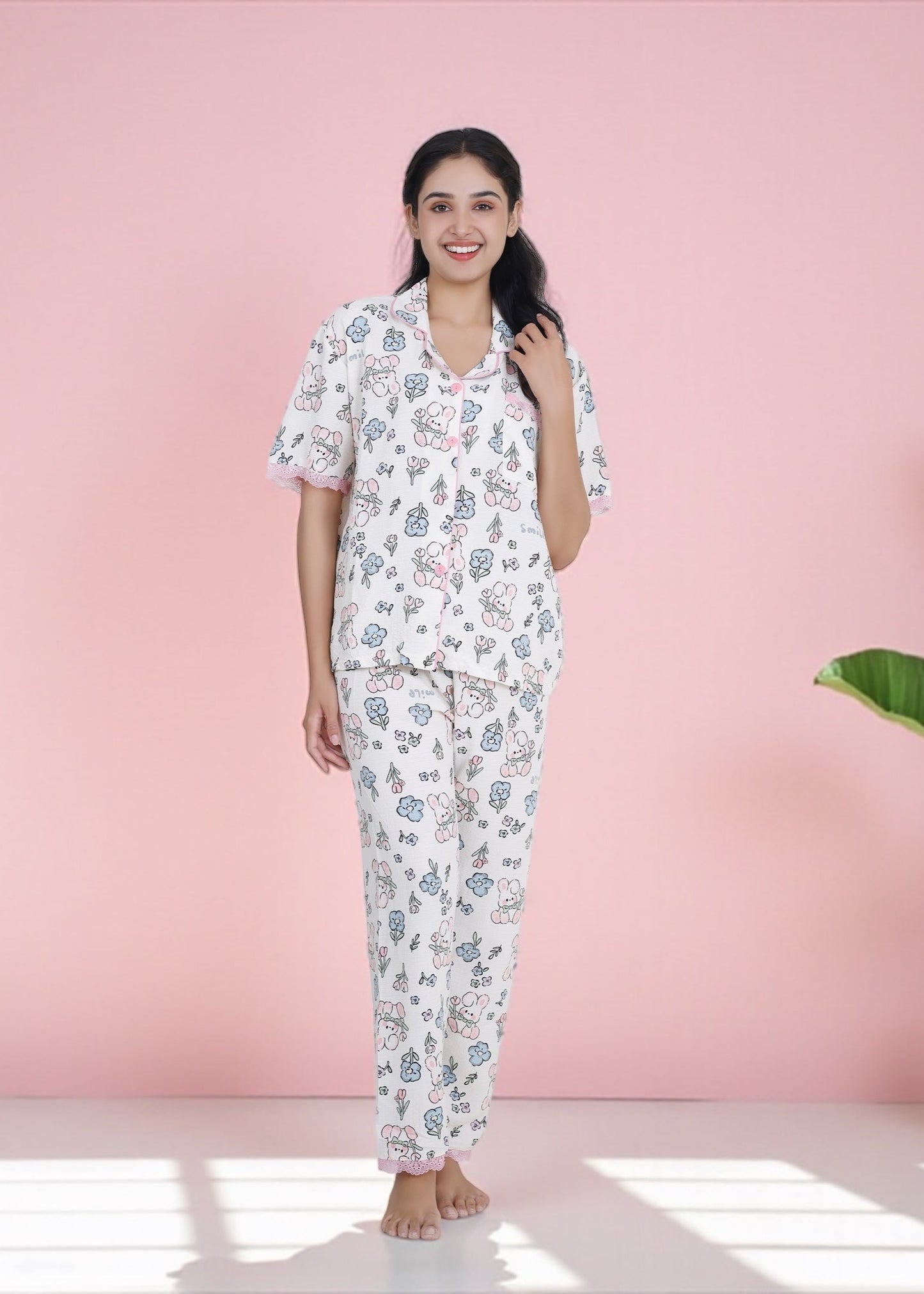 Woman wearing white crepe cotton pyjama set with bunny and floral print and pink frill lace, by WakeUp Chicq.