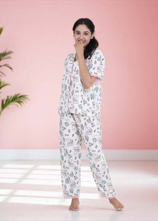 Woman wearing white crepe cotton pyjama set with bunny and floral print and pink frill lace, by WakeUp Chicq.