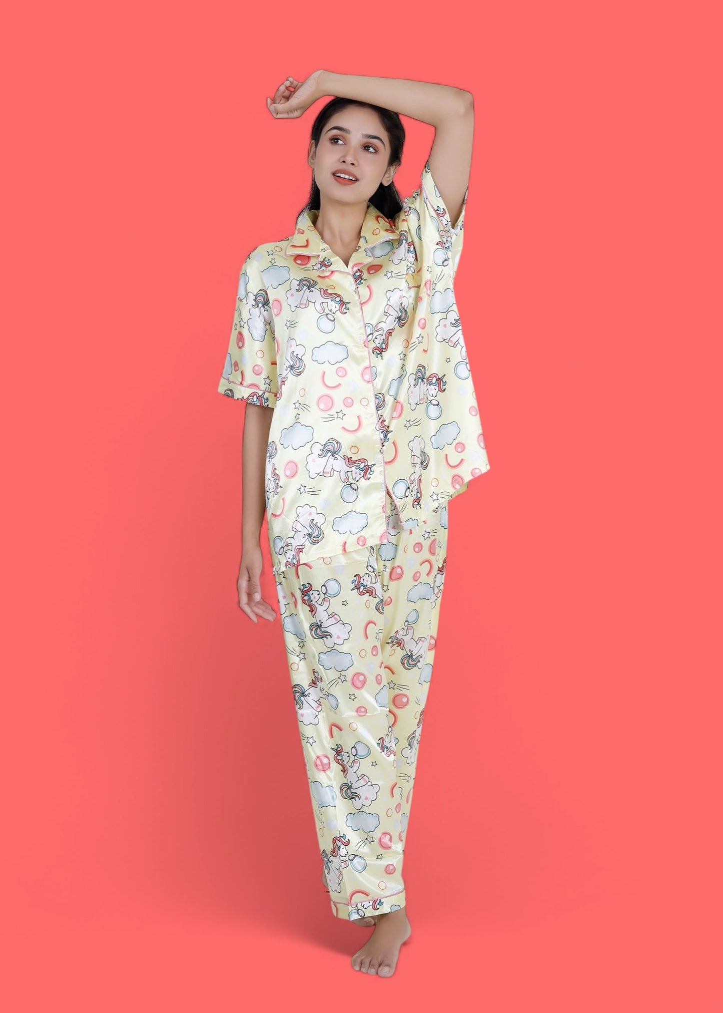 Woman wearing creamy yellow satin unicorn pyjama set with cloud motifs, full-length luxury loungewear by WakeUp Chicq.