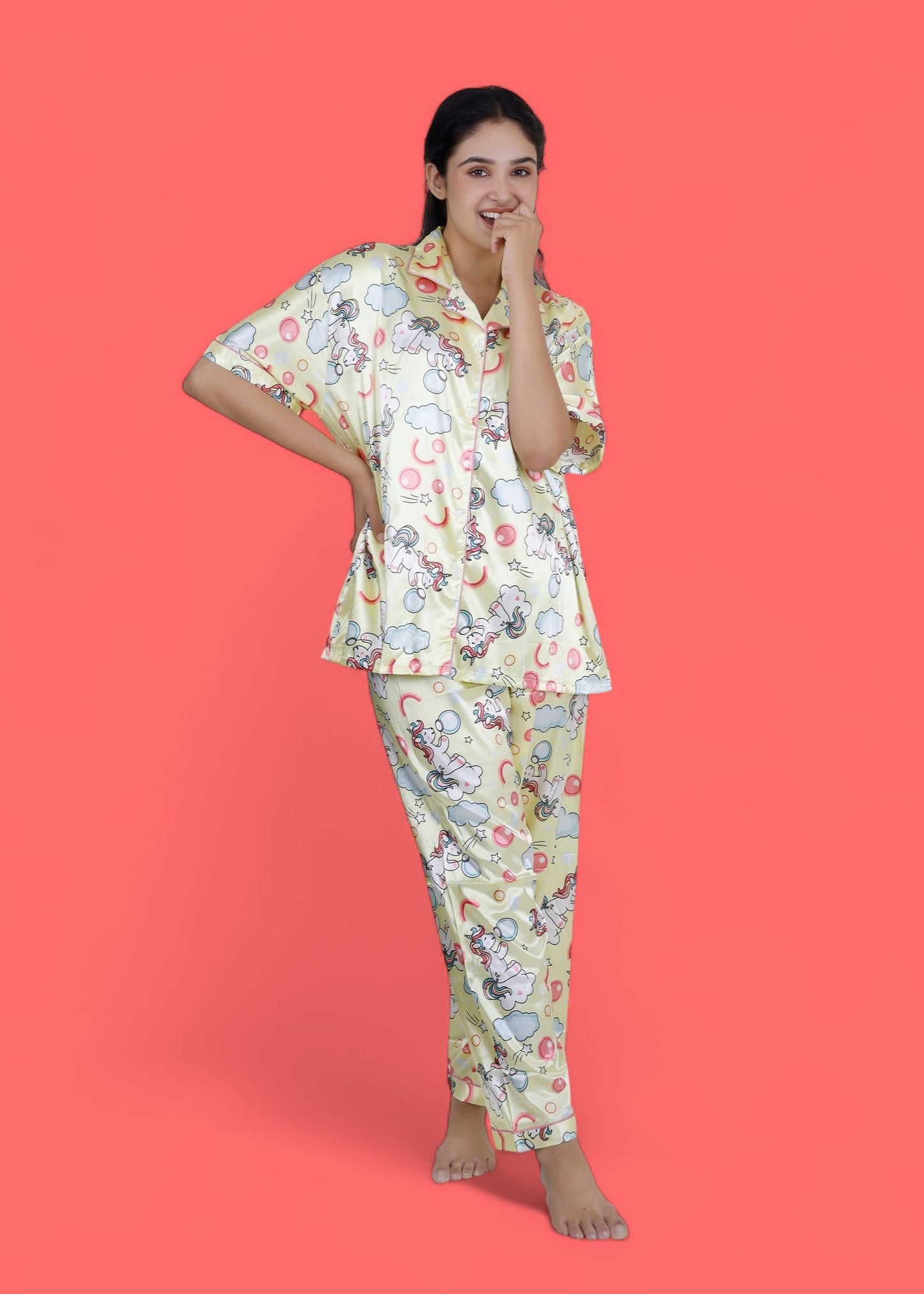 Woman wearing creamy yellow satin unicorn pyjama set with cloud motifs, full-length luxury loungewear by WakeUp Chicq.