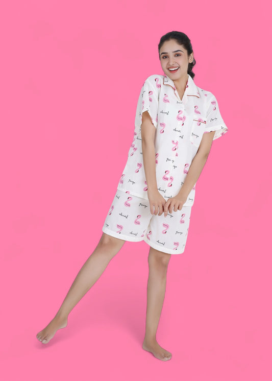 Woman wearing white cotton shorts set with pink flamingo print, lightweight summer loungewear by WakeUp Chicq.