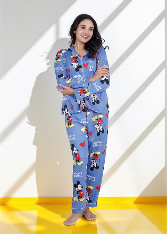 Woman wearing light blue jersey cotton pyjama set with Mickey Mouse print and red piping, Disney-inspired loungewear by WakeUp Chicq.