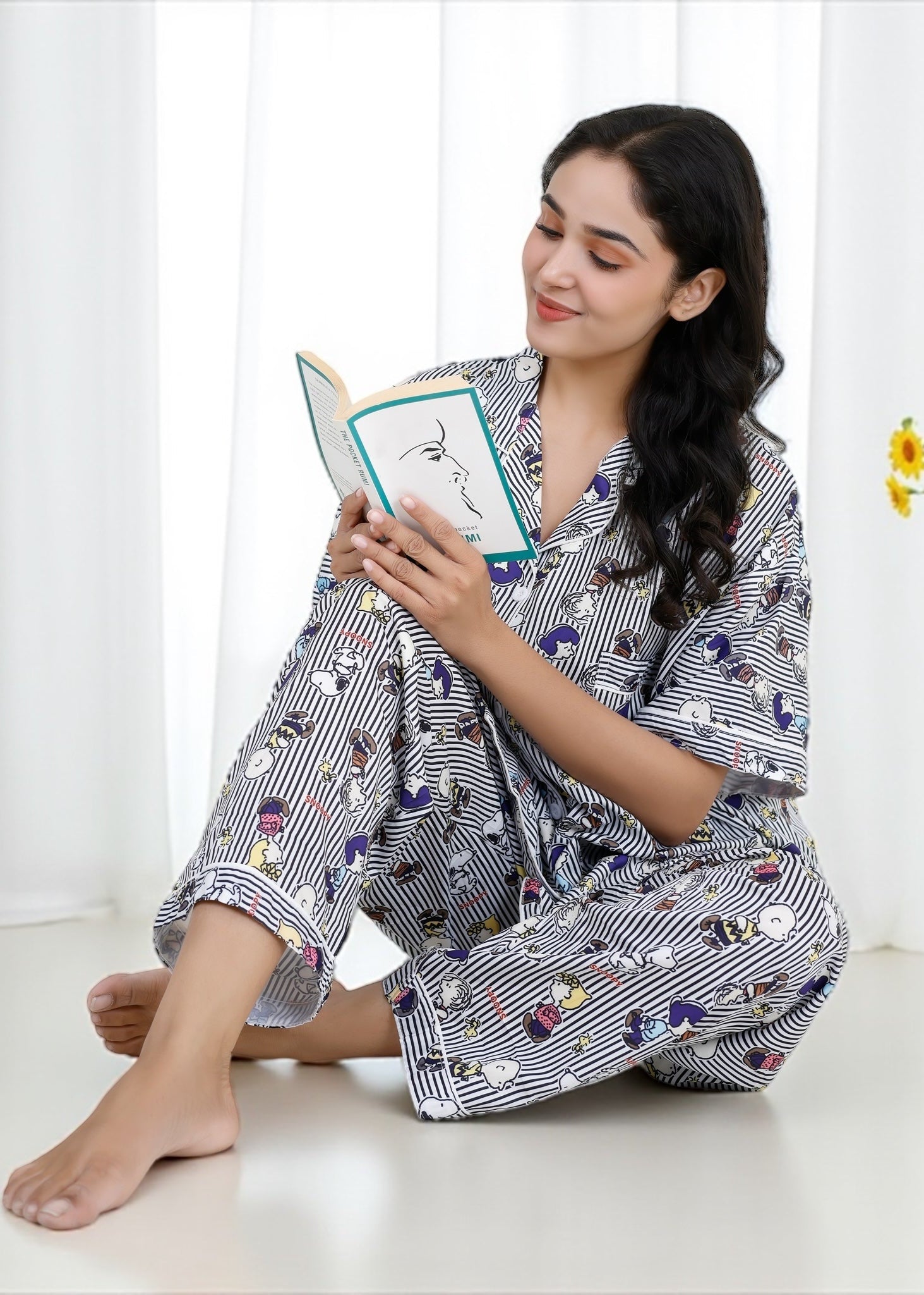 Woman wearing Snoopy cartoon black-and-white striped crepe pyjama set with relaxed fit, stylish nightwear by WakeUp Chicq.