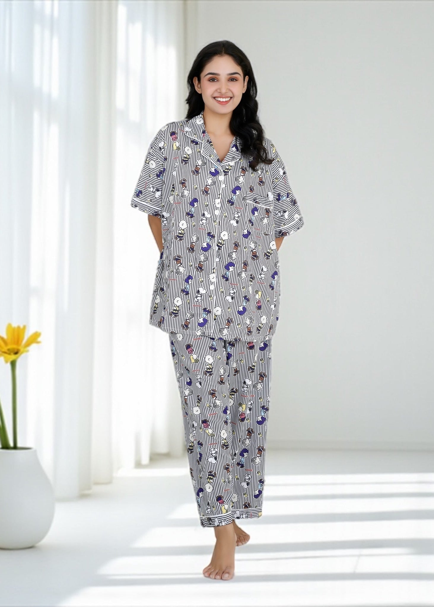 Woman wearing Snoopy cartoon black-and-white striped crepe pyjama set with relaxed fit, stylish nightwear by WakeUp Chicq.