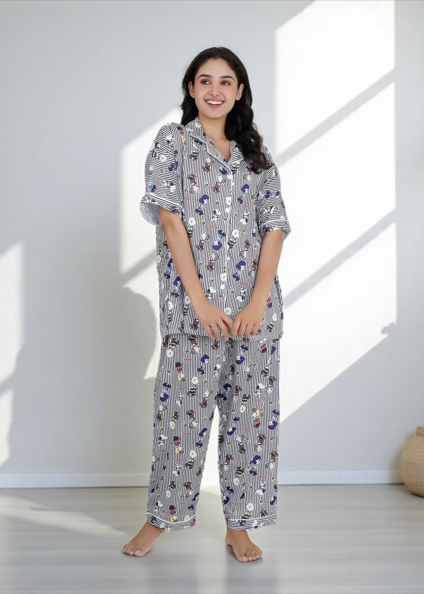 Woman wearing Snoopy cartoon black-and-white striped crepe pyjama set with relaxed fit, stylish nightwear by WakeUp Chicq.