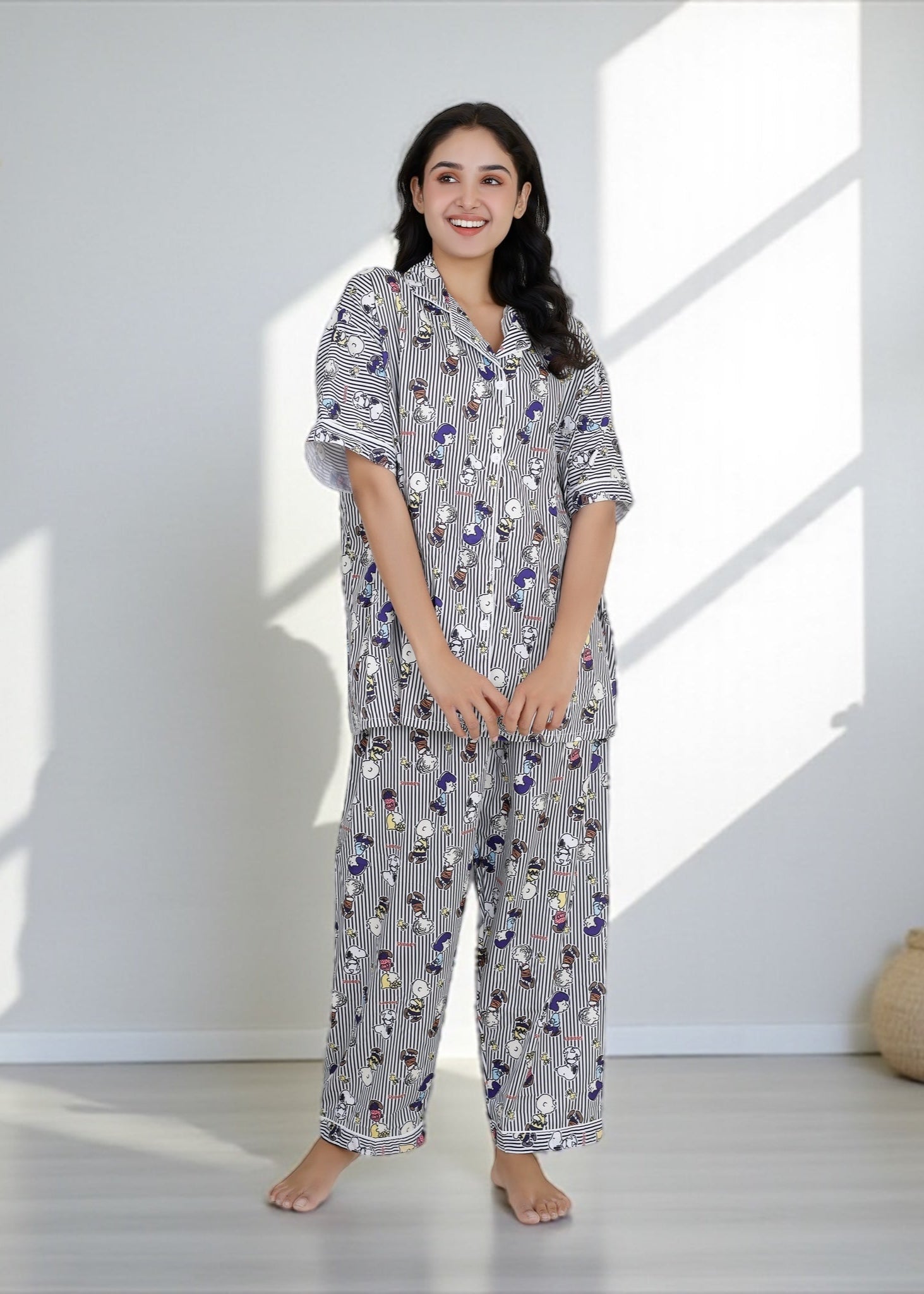 Woman wearing Snoopy cartoon black-and-white striped crepe pyjama set with relaxed fit, stylish nightwear by WakeUp Chicq.