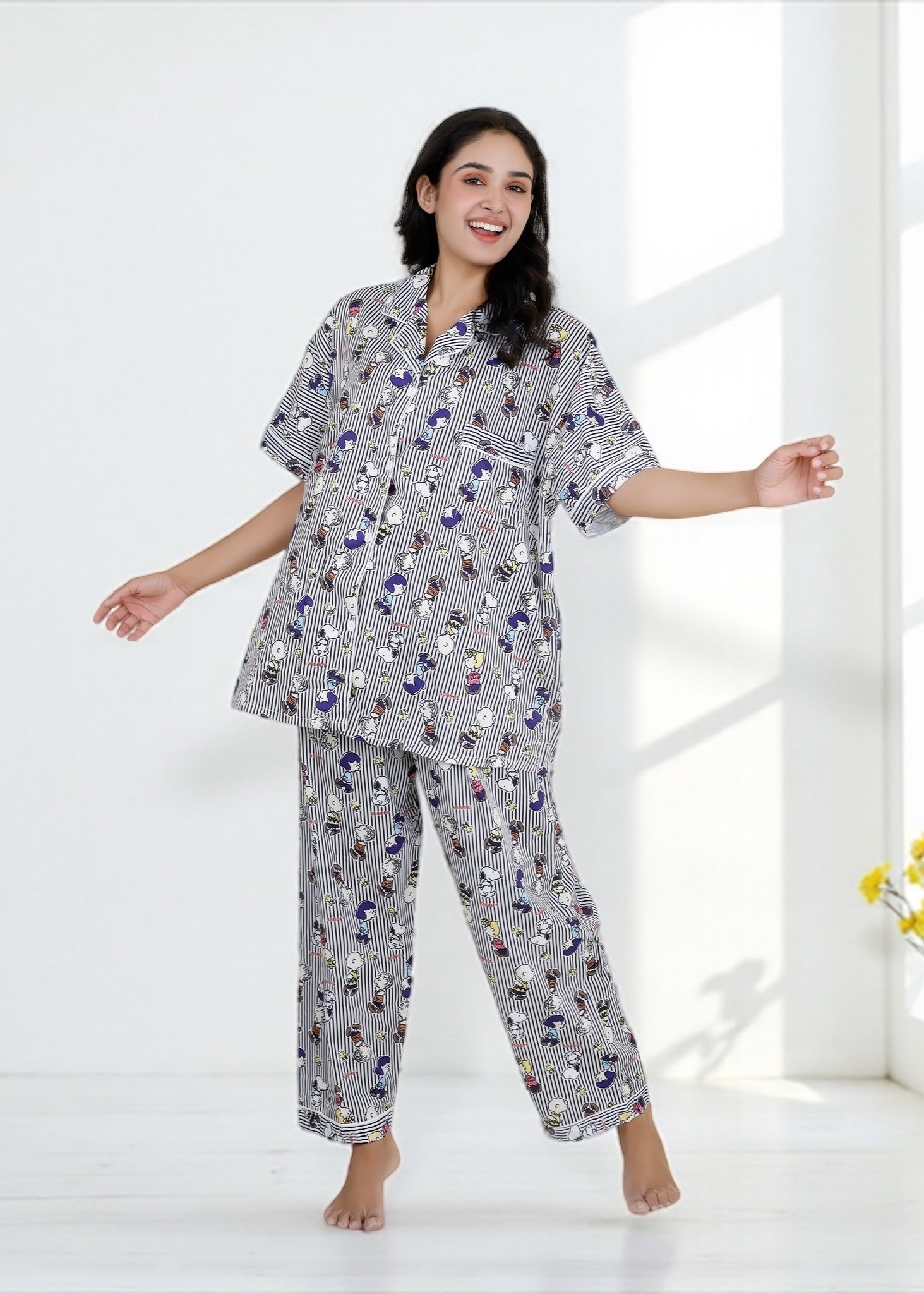 Woman wearing Snoopy cartoon black-and-white striped crepe pyjama set with relaxed fit, stylish nightwear by WakeUp Chicq.
