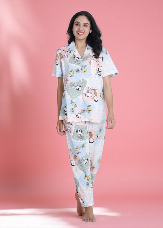 Woman wearing pastel patchwork Snoopy Peanuts cartoon print crushed crepe pyjama set, soft cotton loungewear by WakeUp Chicq.