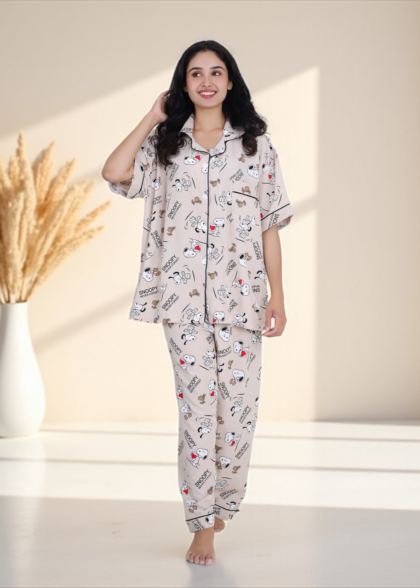 Woman wearing beige crepe cotton pyjama set with Snoopy cartoon print and relaxed oversized fit, by WakeUp Chicq.