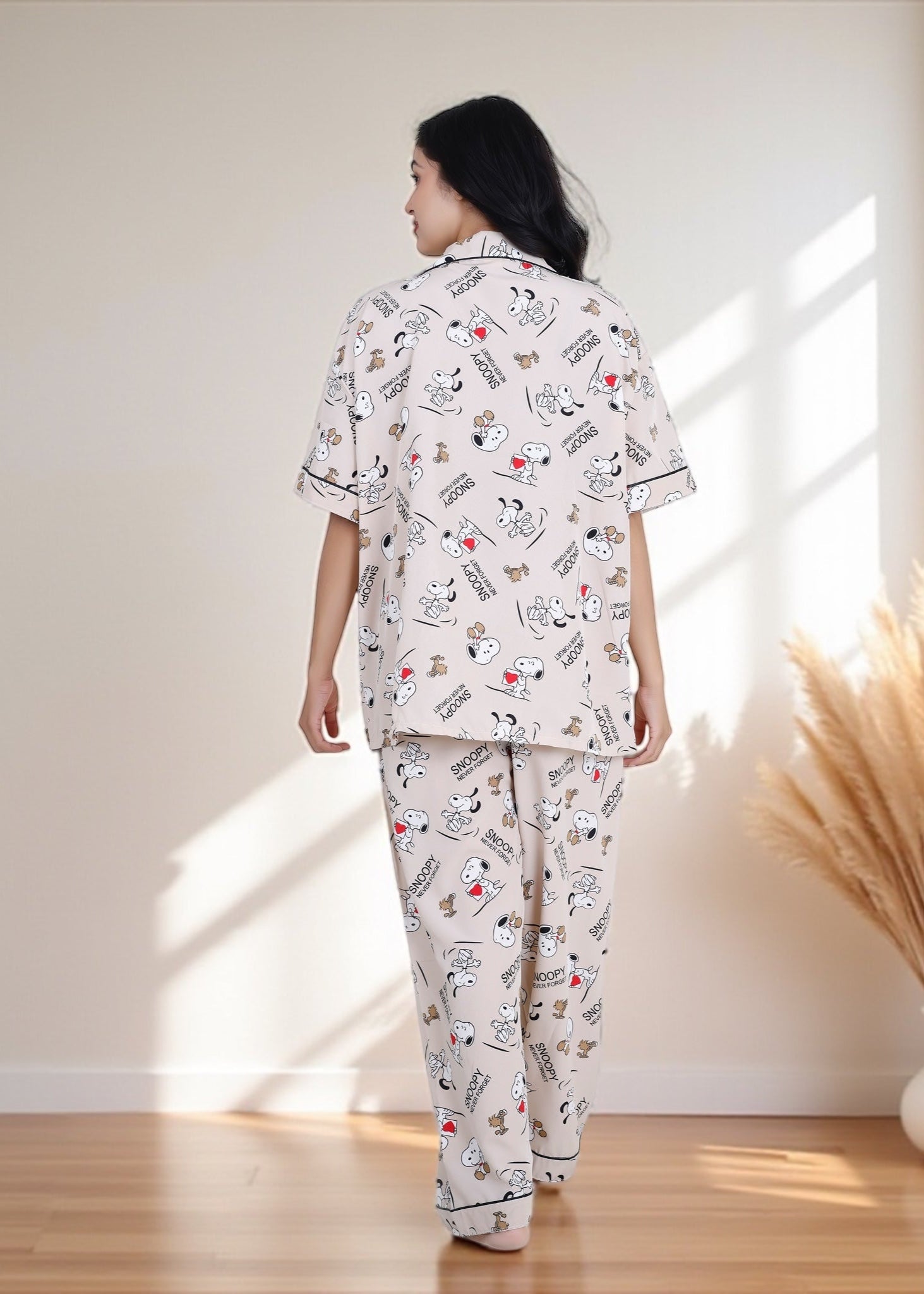 Woman wearing beige crepe cotton pyjama set with Snoopy cartoon print and relaxed oversized fit, by WakeUp Chicq.