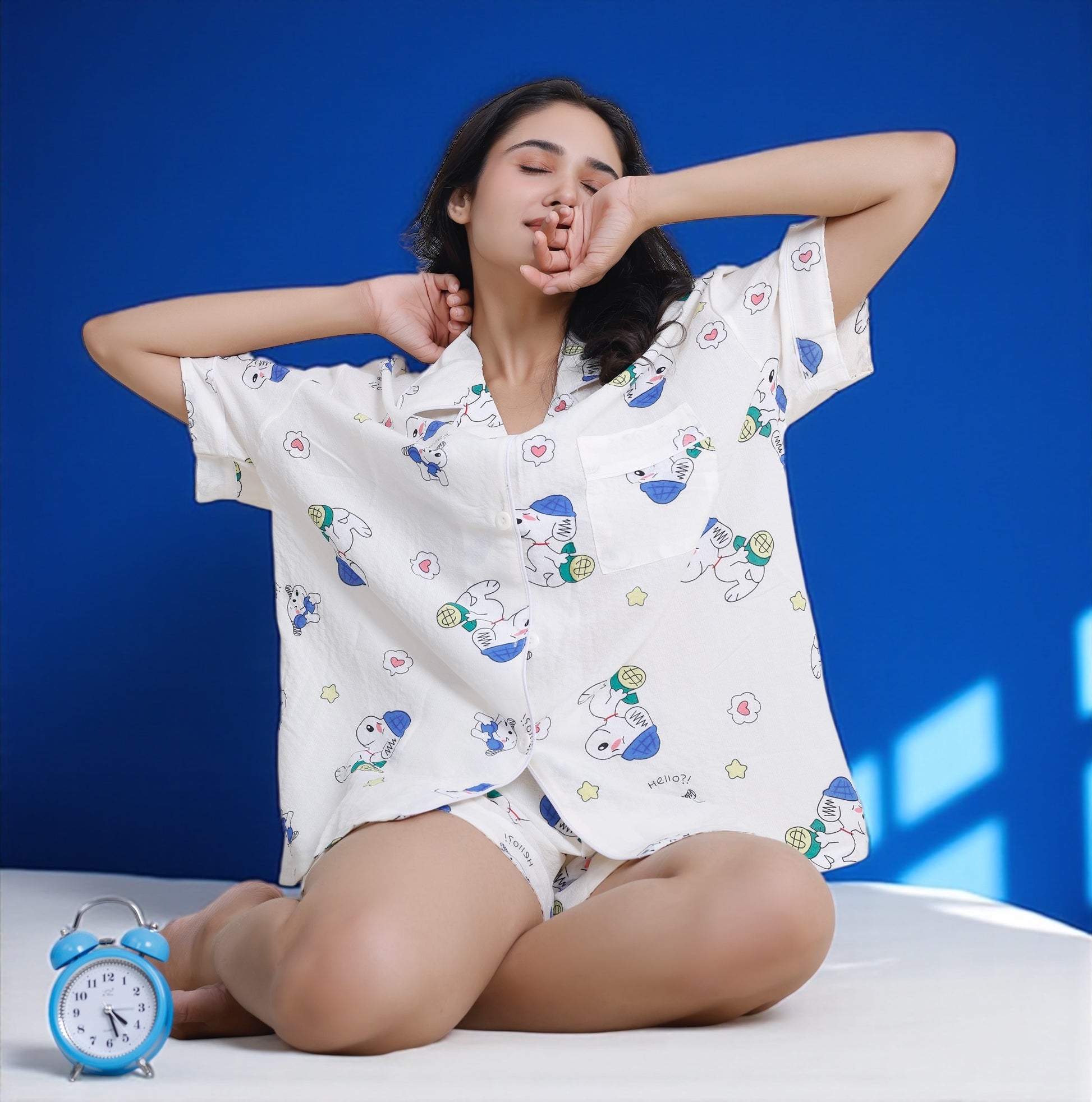 Woman wearing white crushed crepe shorts set with blue and green Snoopy cartoon print, lightweight cotton loungewear by WakeUp Chicq.