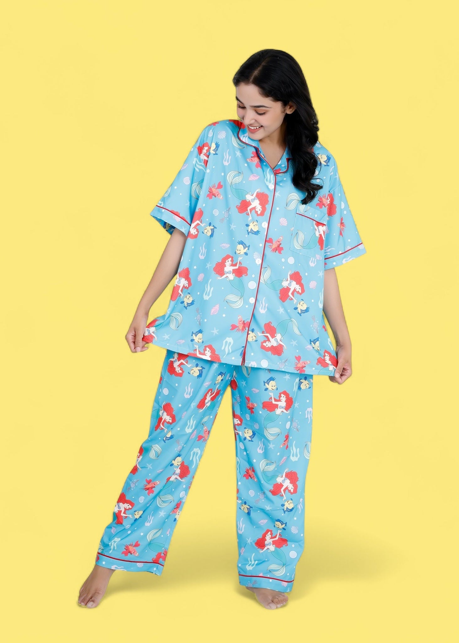 Woman wearing Little Mermaid blue satin pyjama set with underwater mermaid prints

