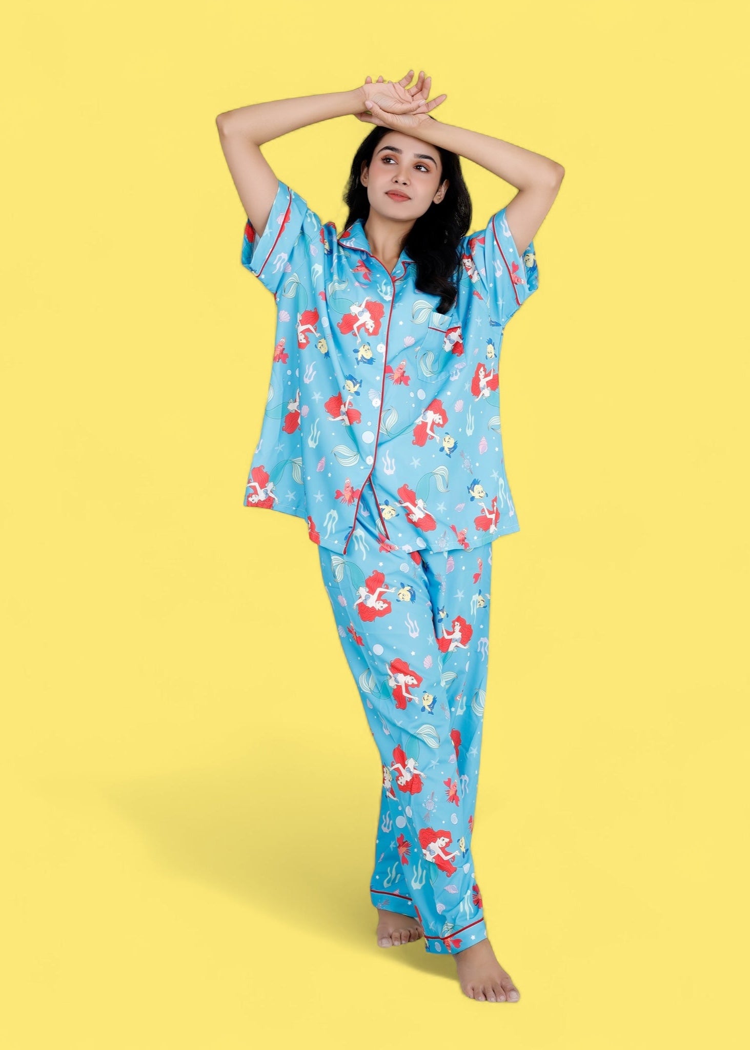Woman wearing Little Mermaid blue satin pyjama set with underwater mermaid prints

