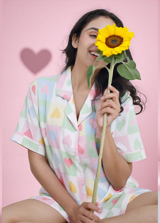 Woman wearing pastel multicolor heart cotton shorts set with notched collar shirt, relaxed loungewear by WakeUp Chicq.

