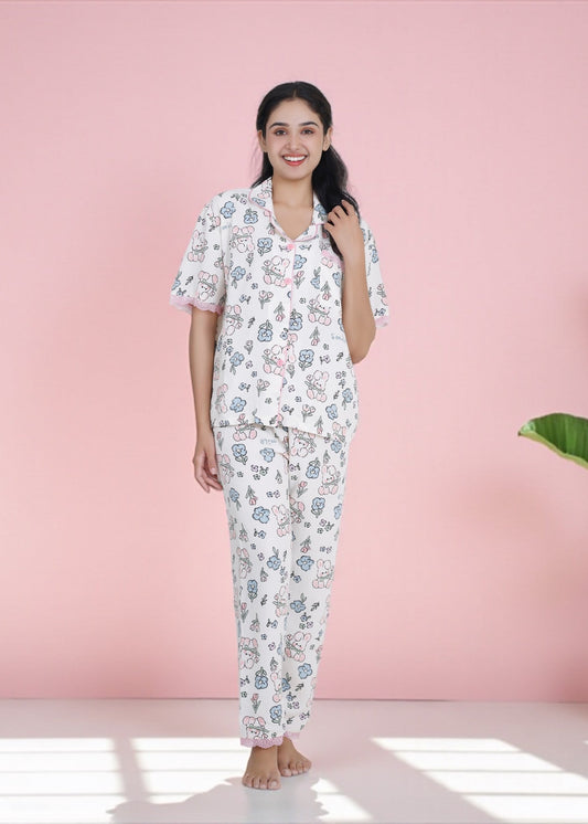 Woman wearing white crepe cotton pyjama set with bunny and floral print and pink frill lace, by WakeUp Chicq.
