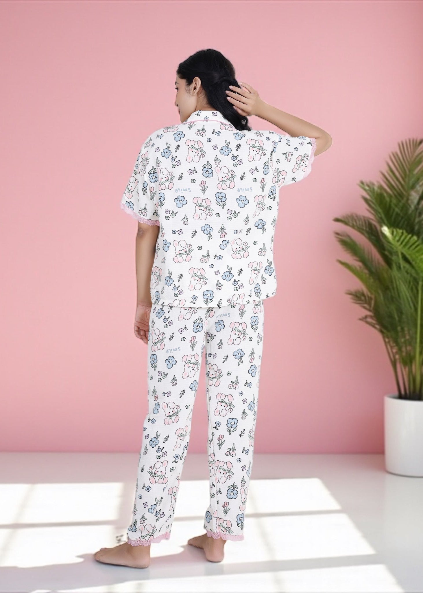 Woman wearing white crepe cotton pyjama set with bunny and floral print and pink frill lace, by WakeUp Chicq.