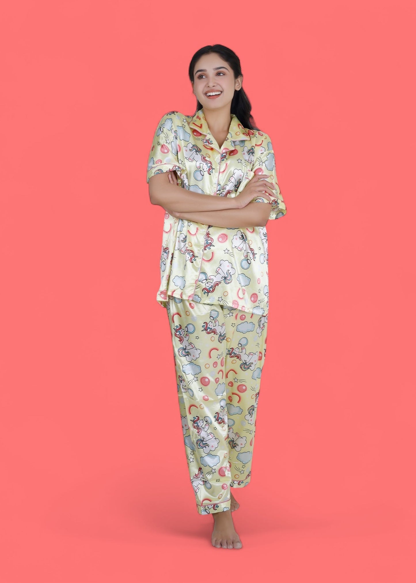 Woman wearing creamy yellow satin unicorn pyjama set with cloud motifs, full-length luxury loungewear by WakeUp Chicq.