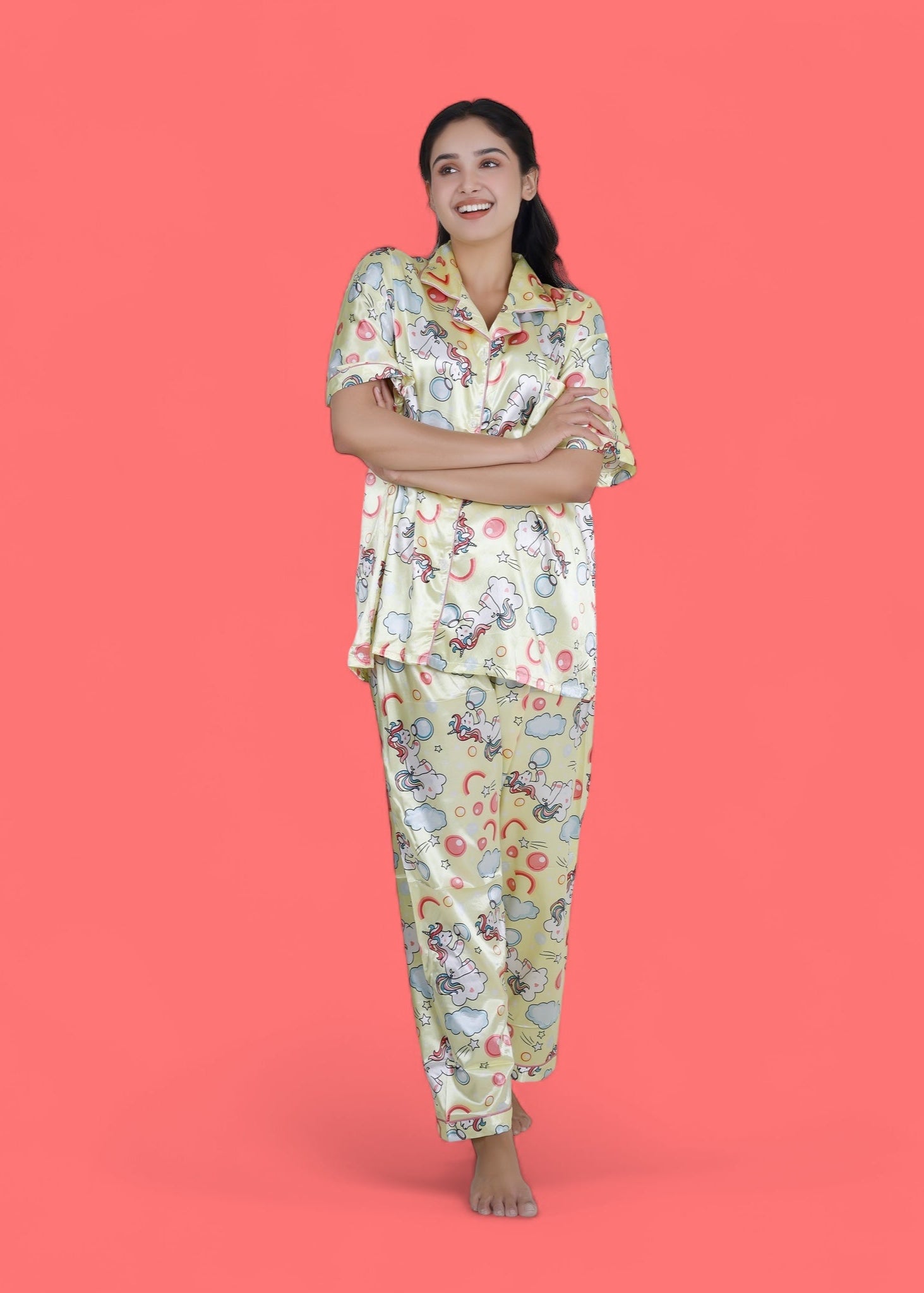 Woman wearing creamy yellow satin unicorn pyjama set with cloud motifs, full-length luxury loungewear by WakeUp Chicq.