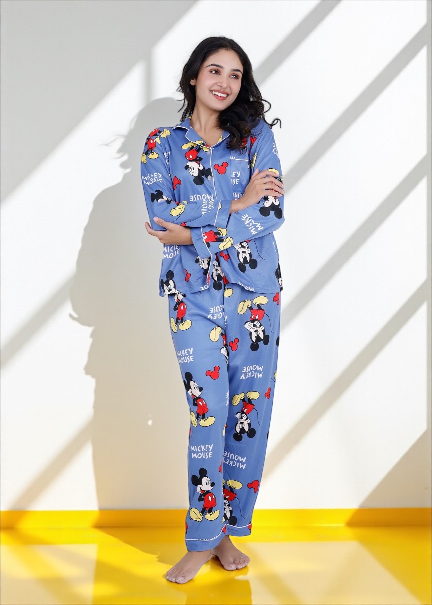 Woman wearing light blue jersey cotton pyjama set with Mickey Mouse print and red piping, Disney-inspired loungewear by WakeUp Chicq.

