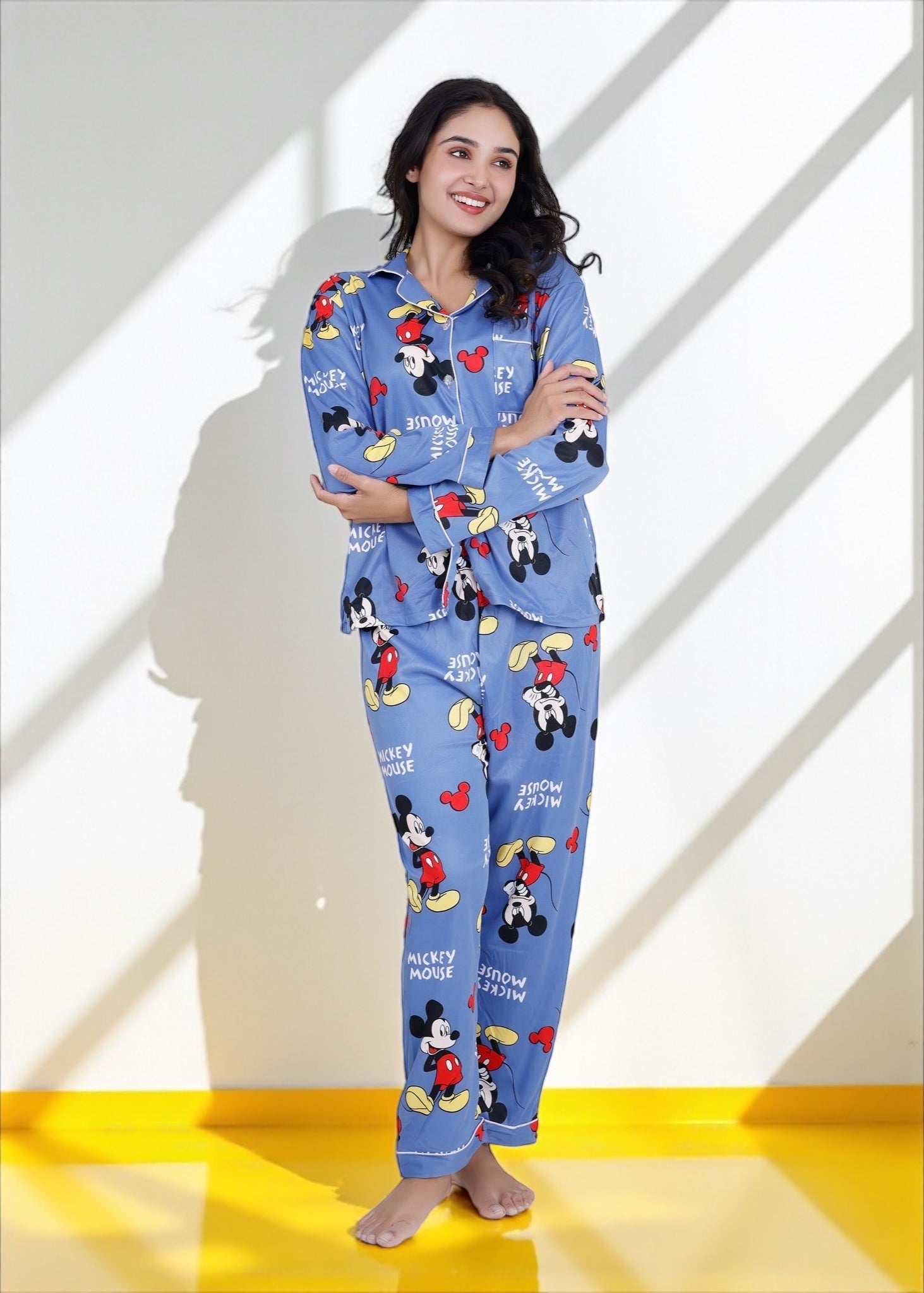 Woman wearing light blue jersey cotton pyjama set with Mickey Mouse print and red piping, Disney-inspired loungewear by WakeUp Chicq.

