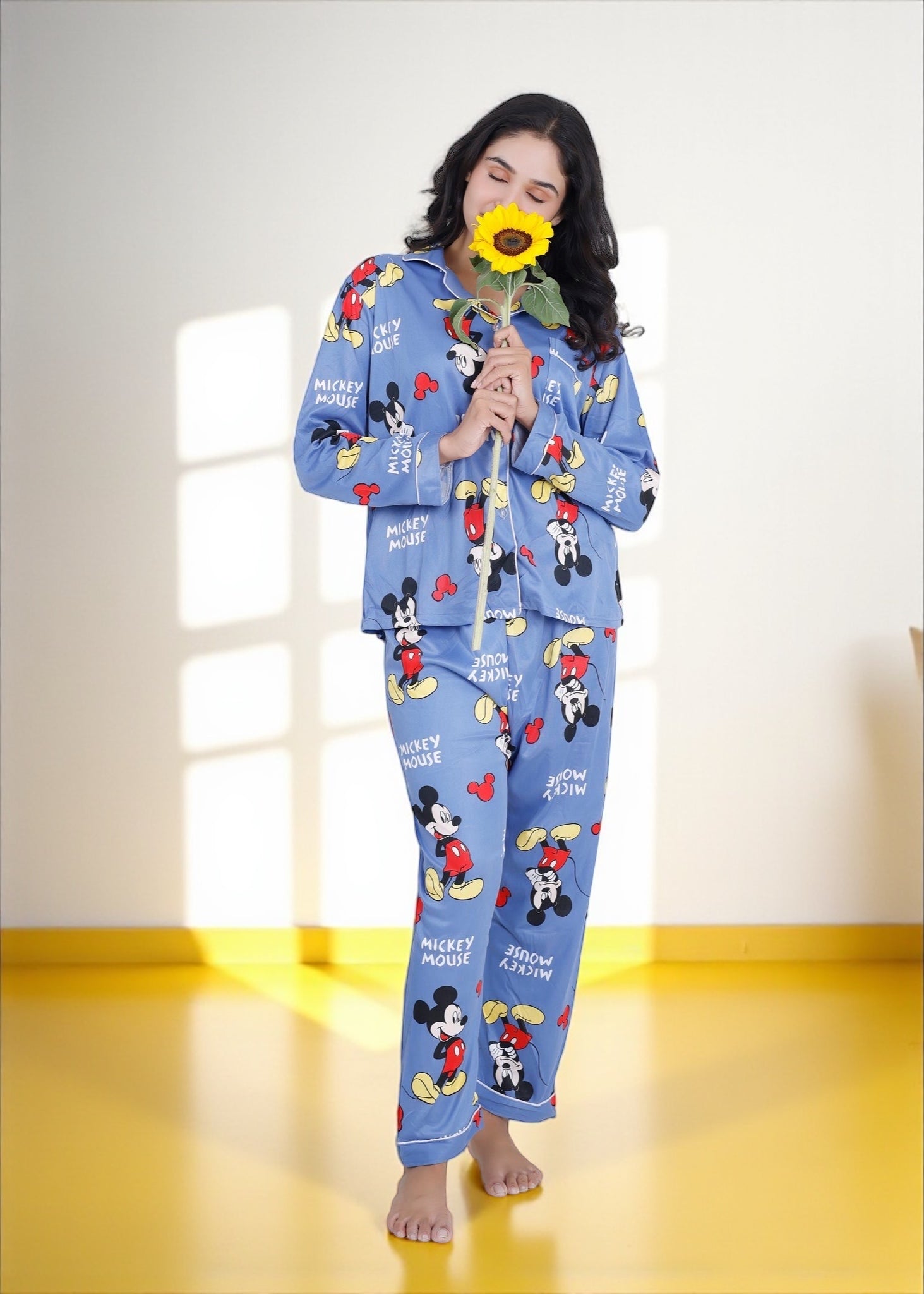 Woman wearing light blue jersey cotton pyjama set with Mickey Mouse print and red piping, Disney-inspired loungewear by WakeUp Chicq.

