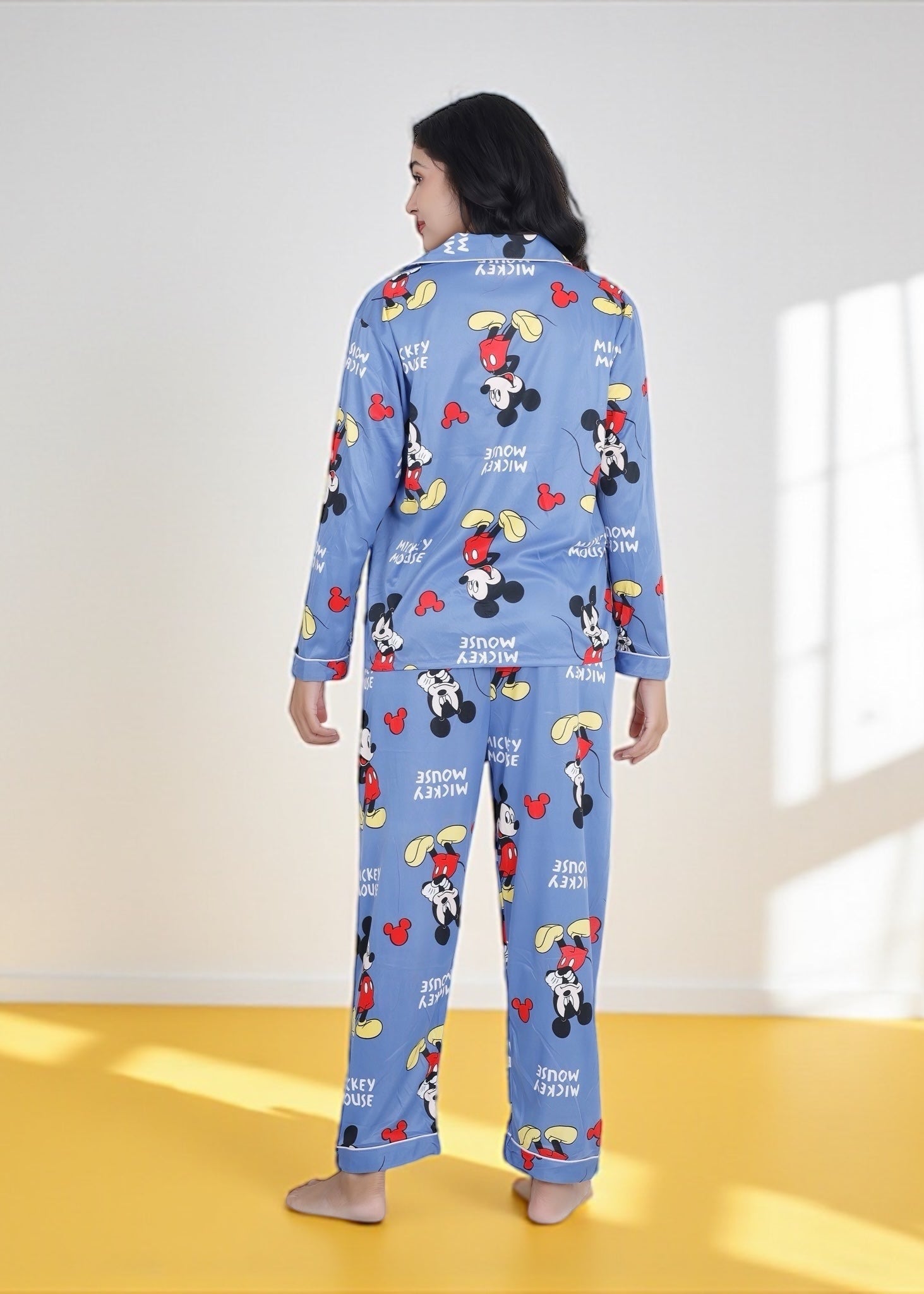 Woman wearing light blue jersey cotton pyjama set with Mickey Mouse print and red piping, Disney-inspired loungewear by WakeUp Chicq.

