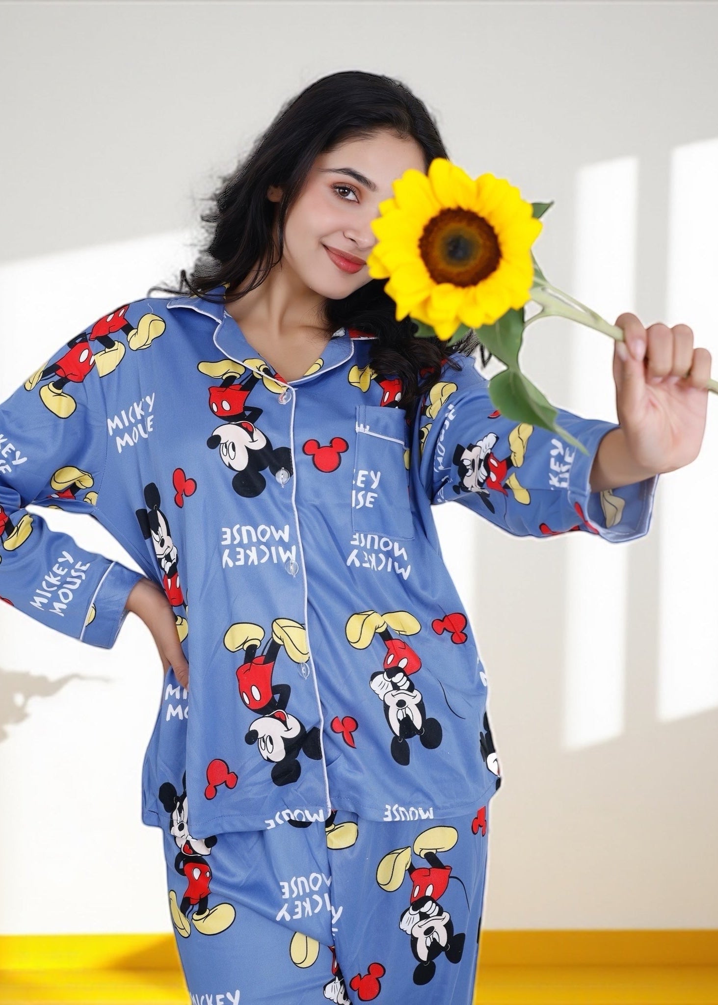 Woman wearing light blue jersey cotton pyjama set with Mickey Mouse print and red piping, Disney-inspired loungewear by WakeUp Chicq.

